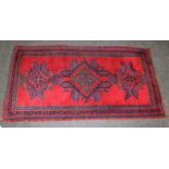 A mid 20th century Turkish Ushak rug, woven with latch hook lozenge medallions on a madder ground.