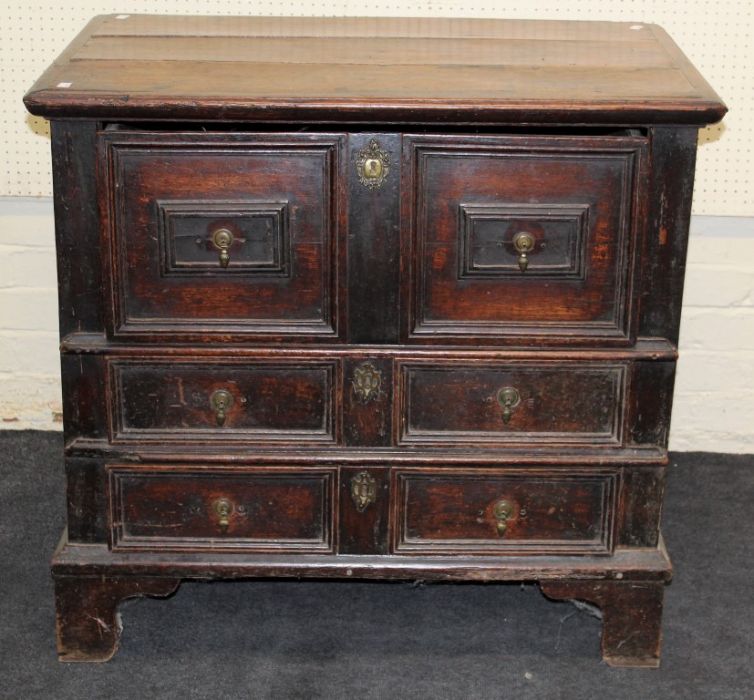 A 17th century oak chest, the rectangular planked top over single deep and two shallow long