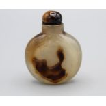 Snuff Bottle. Chalcedony of flattened round form with a small oval base, the darker inclusions in