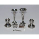 A pair of short loaded candlesticks, two loaded posy vases, a silver lidded cosmetics box plus a
