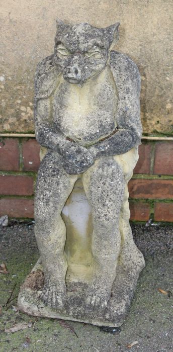 A nicely weathered reconstituted stone model of a gargoyle, seated upon a plinth, 72cm high