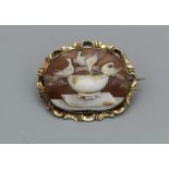 A shell cameo brooch, featuring doves in a bird bath, in unmarked yellow metal. Cameo measures