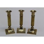 A trio of columnar brass candlesticks made in India