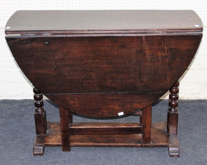 A late 18th century oak gateleg table of pegged construction, the rectangular top and twin demi-lune