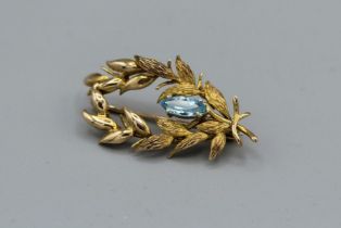 An aquamarine set laurel spray brooch in 9ct gold hallmarked setting, as found due to split in the