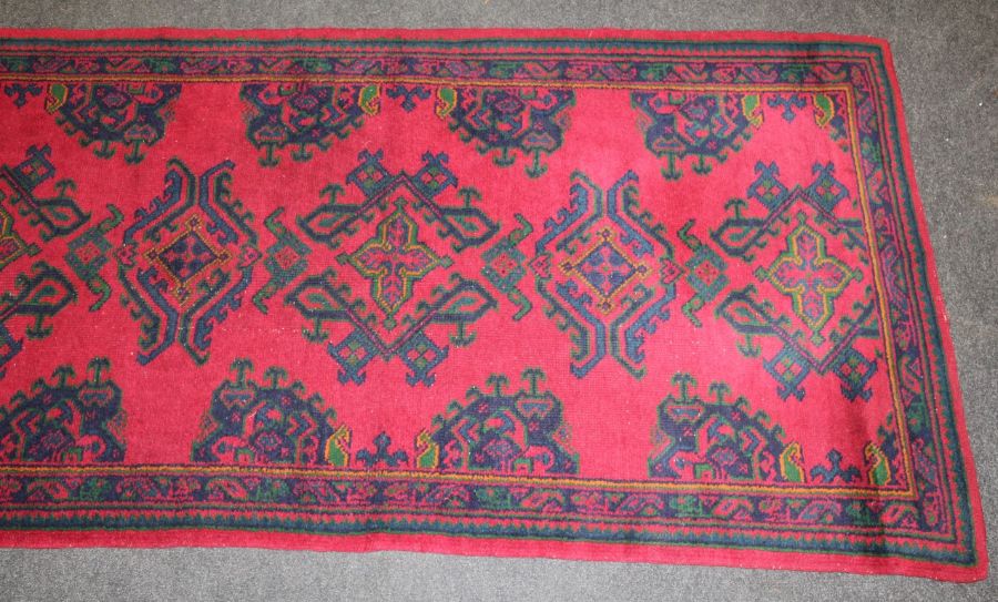 A mid 20th century Turkish Ushak rug woven with latch hook lozenge medallions on a madder ground.