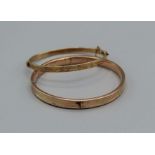 A pair of engraved bangles,, one hallmarked hinge bangle with safety chain, approximate weight 12.