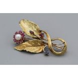 A ruby, sapphire and cultured pearl set spray brooch in yellow metal, stamped 14k to the pin,