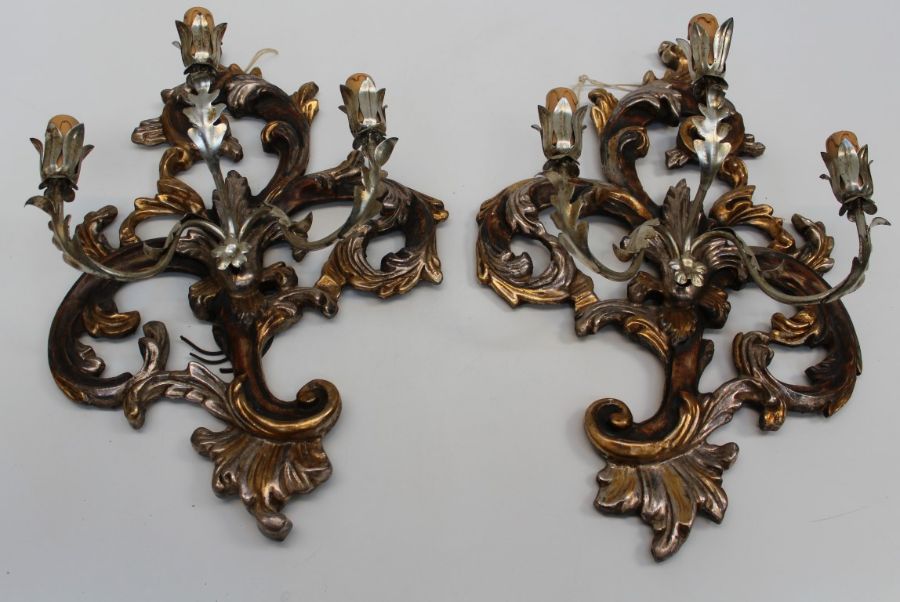 A pair of 20th century Rococo form carved wood, metal and parcel gilt three light wall sconces, 60cm