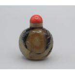 Snuff Bottle. Chalcedony of rounded rectangular form with a small oval base, carved in low relief