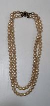 A double stranded pearl choker with a yellow metal clasp, stamped 9ct and  set with split pearls and