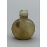 Snuff Bottle. Chalcedony of compressed round form on a raised footrim, carved in low relief with two