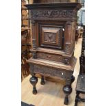 Continental solid oak carved cabinet on stand, with central cupboard door flanked by two classical