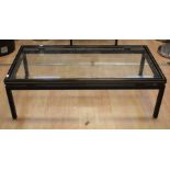 A Pierre Vandel low coffee table in black and gold metal with glass insert top