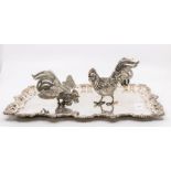 A pair of Middle Eastern white metal low grade models of fighting cocks, stamped on wings and