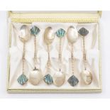 A cased set of white metal spoons, stamped STC, with twisted stems and carved abalone shell