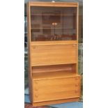 A mid century teak cabinet with glazed bookshelf top and 3 drawer cupboard to the base. Height