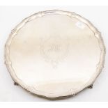 A silver salver with beaded edge, raise rim with foliate motifs, ball and claw feet, with later