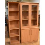 A modern, glazed bookcase ot two doors above two cupboards, along with matching bookshelves