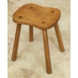 Workshop of Robert 'Mouseman' Thompson a four legged oak stool with dished rectangular top.