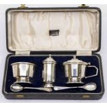 An Art Deco three-piece silver condiment set to include salt, mustard pot and pepper pot, hallmarked