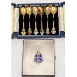 A Modern matched set of six silver gilt and enamel teaspoons, each terminal decorated with various