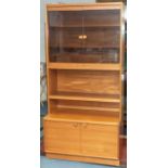 A mid century teak cabinet with glazed bookshelf top and 2 door cupboard to the base. Height