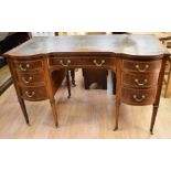 An Edwardian ladies' desk with brown leather insert, central top drawer flanked by three bowed