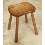 Workshop of Robert 'Mouseman' Thompson a four legged oak stool with dished rectangular top.