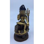 A 20th century North Indian gilt and polychrome painted cupro-bronze figure of a deity holding a