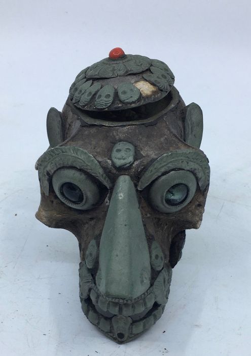 A 20th century Sino-Tibetan metal mounted monkey skull, hinged to skull top, length 14cm.