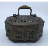 A 20th century Indian brass pierced casket or censer, with hinged handle, raised upon four ball