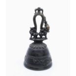 A late Ming style bronze vessel in the form of a Bell, with loop cast handle and Dog of Fo