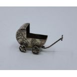A late 19th century miniature silver pram, impressed Hanau pseudo marks, repousse cherubs, length