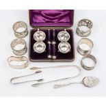 A collection of silver to include: an Edwardian pierced napkin ring, decorated with putti beside