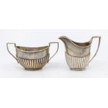 A late Victorian silver cream jug with gadrooned lower body, height approx 10cm, London 1883,