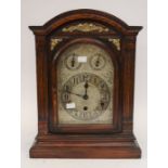 A large 19th century mahogany mantel clock with arched silvered dial, Arabic numerals and