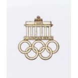 A 1936 Berlin Olympics visitors badge. Steel base metal with gilt finish and infilled with white