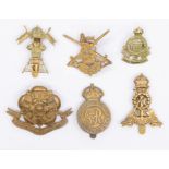 A selection of WWI and later British cap badges, including an all brass die stamped Royal Military