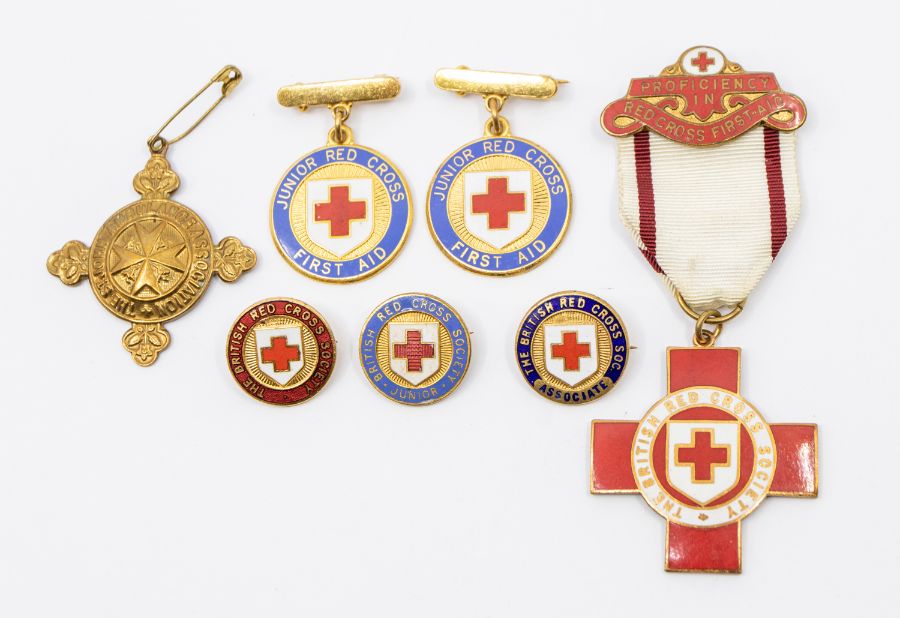 A collection of British Red Cross enamel medallions and badges, including a proficiency medal, two