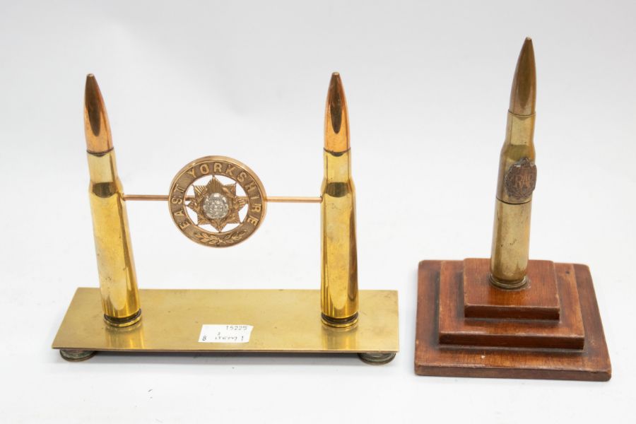 A WWI era trench art bullet table lighter, on a stepped wooden plinth, the bullet has an applied RAF