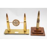 A WWI era trench art bullet table lighter, on a stepped wooden plinth, the bullet has an applied RAF