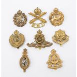 A selection of WWI interwar British cap badges, including a die stamped brass machine gun Corps