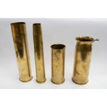 Four brass artillery shells of various dates, including a German 75mm shell, dated 1917, faint