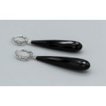 A pair of white metal (stamped 18K 750) ear drops set with six graduated diamonds each, with black