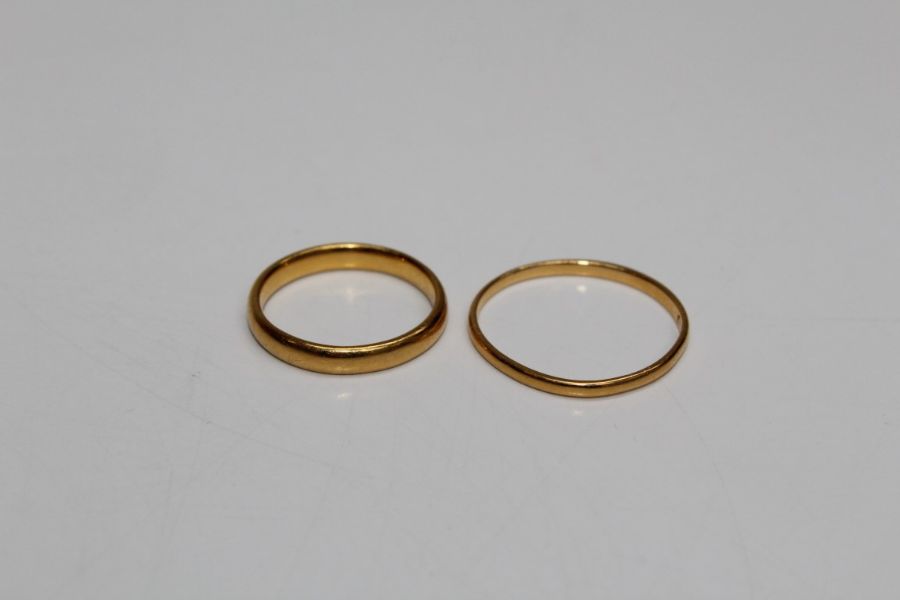 A pair of wedding bands, one hallmarked 22ct gold (approximate weight 3.4gm) and a second yellow