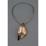 A hand made yellow metal articulated collar with a chunky handmade wave shaped drop, also in