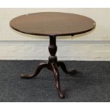 A George III mahogany snap top occasional table, the circular top on a baluster column and tripod