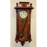 A late 19th century walnut cased Vienna wall clock, the twin train movement striking upon gong,