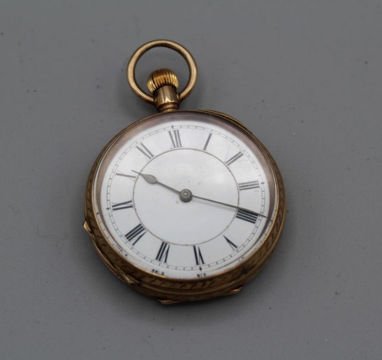 A yellow metal ladies fob watch stamped 9ct, white dial with Roman numerals, winds but does not